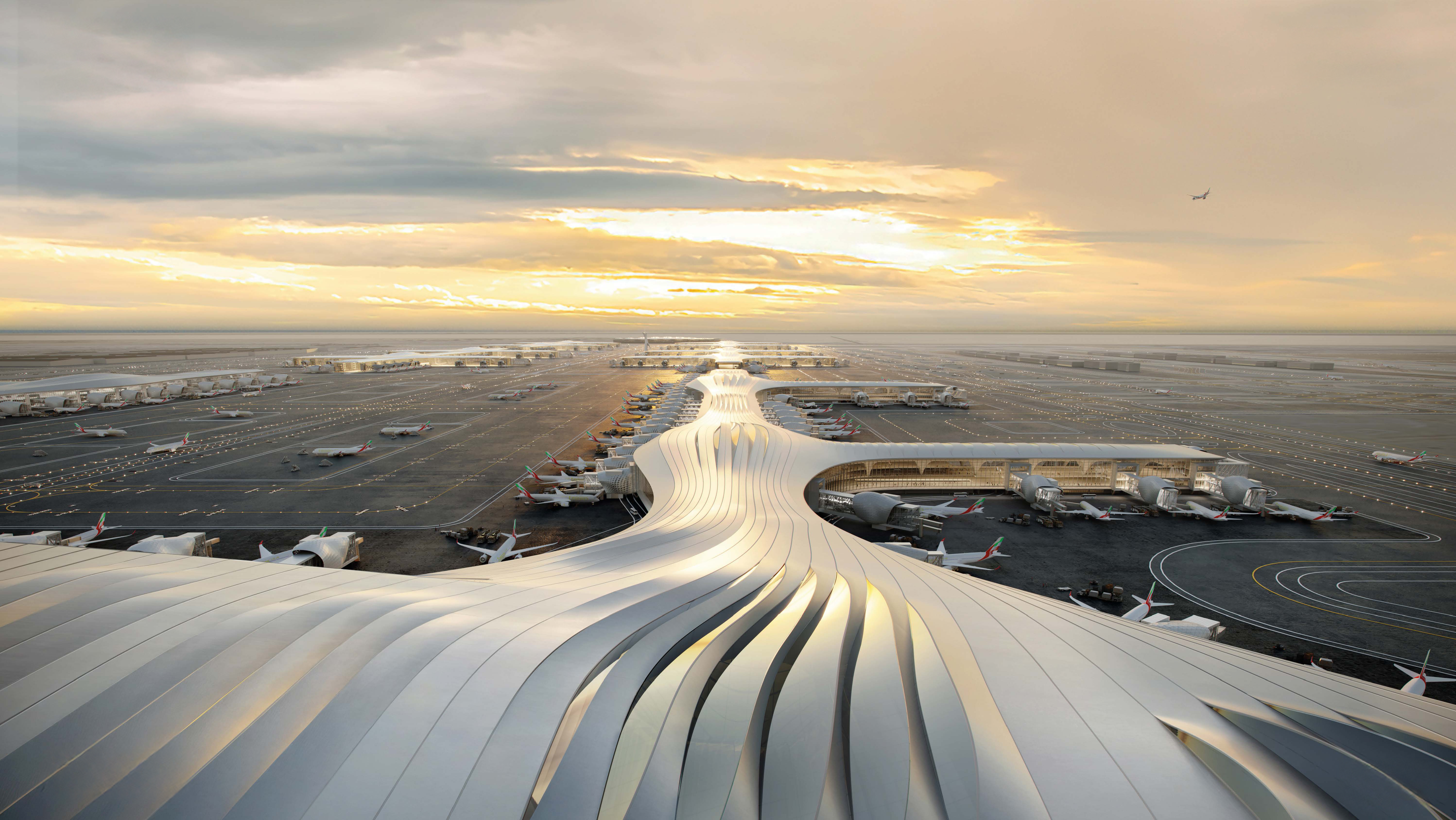 Night-time view of all concourses at DWC and the West Terminal building, lit up.